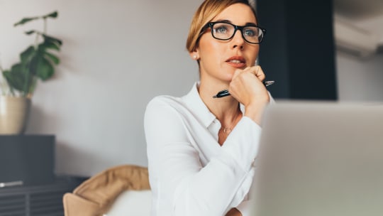 woman thinking while on her laptop