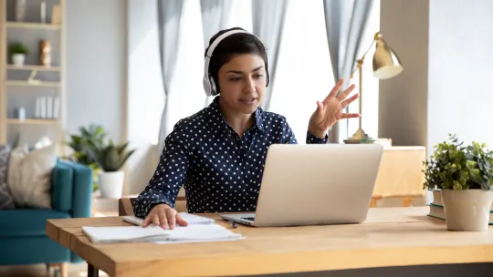 Woman sitting in front of laptop with headlines explaining.