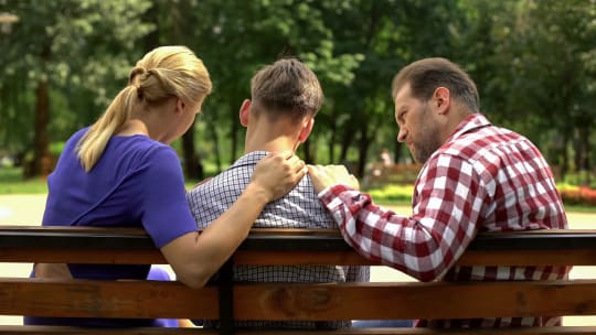 mother and father talking to son