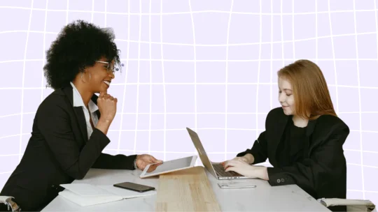 Meeting between woman on tablet and woman on laptop