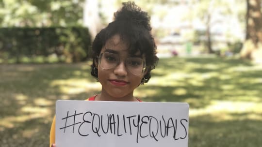 Young woman holding sign about equality