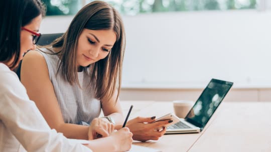 Woman looking at colleague's paper