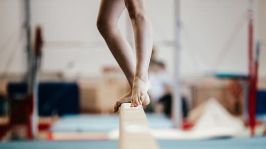 gymnast standing on a beam