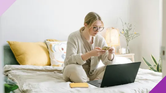 A woman at home, using a budgeting app on her smartphone