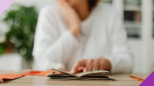 A woman looking at money on a table, illustrating the importance of building better money habits