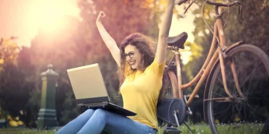Woman with laptop cheering