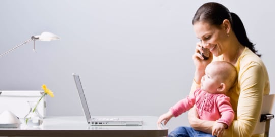 Woman holding baby at desk