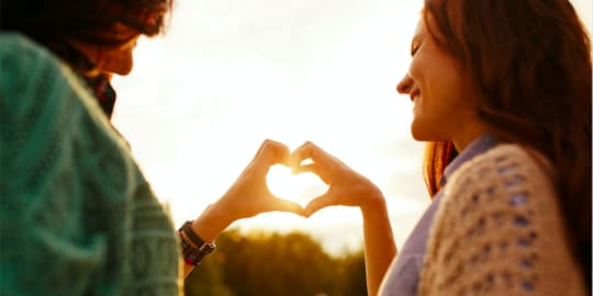 Women making a heart shape
