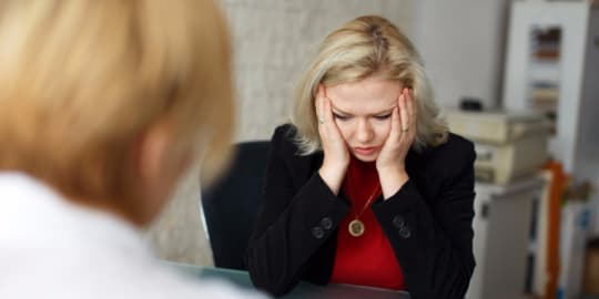 Woman at desk listening to others