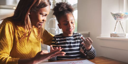 mother doing homework with daughter