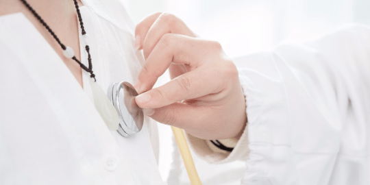 Nurse listening to patient's heartbeat