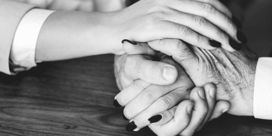 woman holding hands with older person
