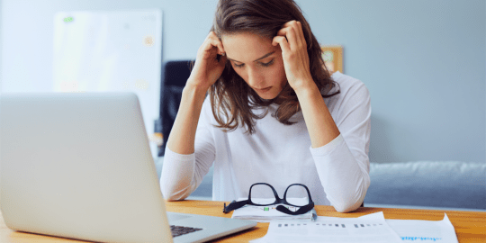 stressed woman with her face in her hands