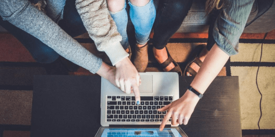 Millennials gathered around a laptop