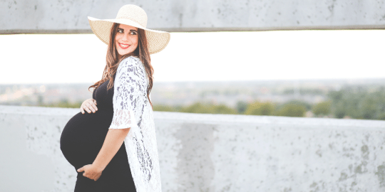 Pregnant woman wearing hat outside