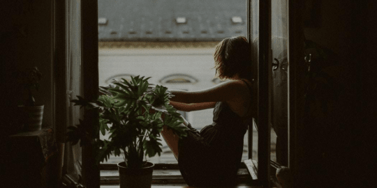 woman sitting by window looking out