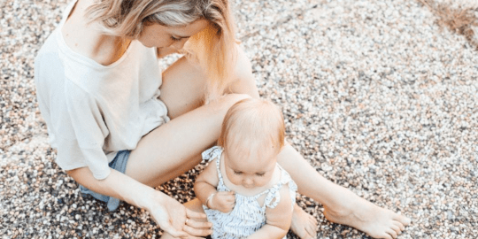 mother sitting with her daughter on the sidewalk