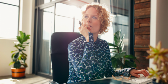 woman thinking with a notepad in front of her