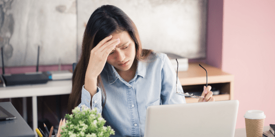 woman looking stressed in front of her laptop