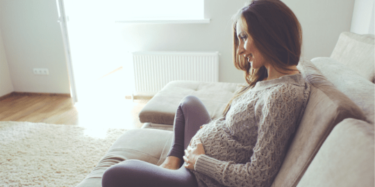 A pregnant woman holds her belly
