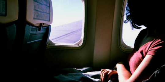 woman looking out of airplane window