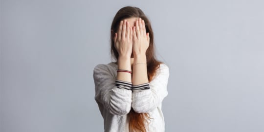 woman shielding face