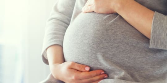 Pregnant woman holding belly