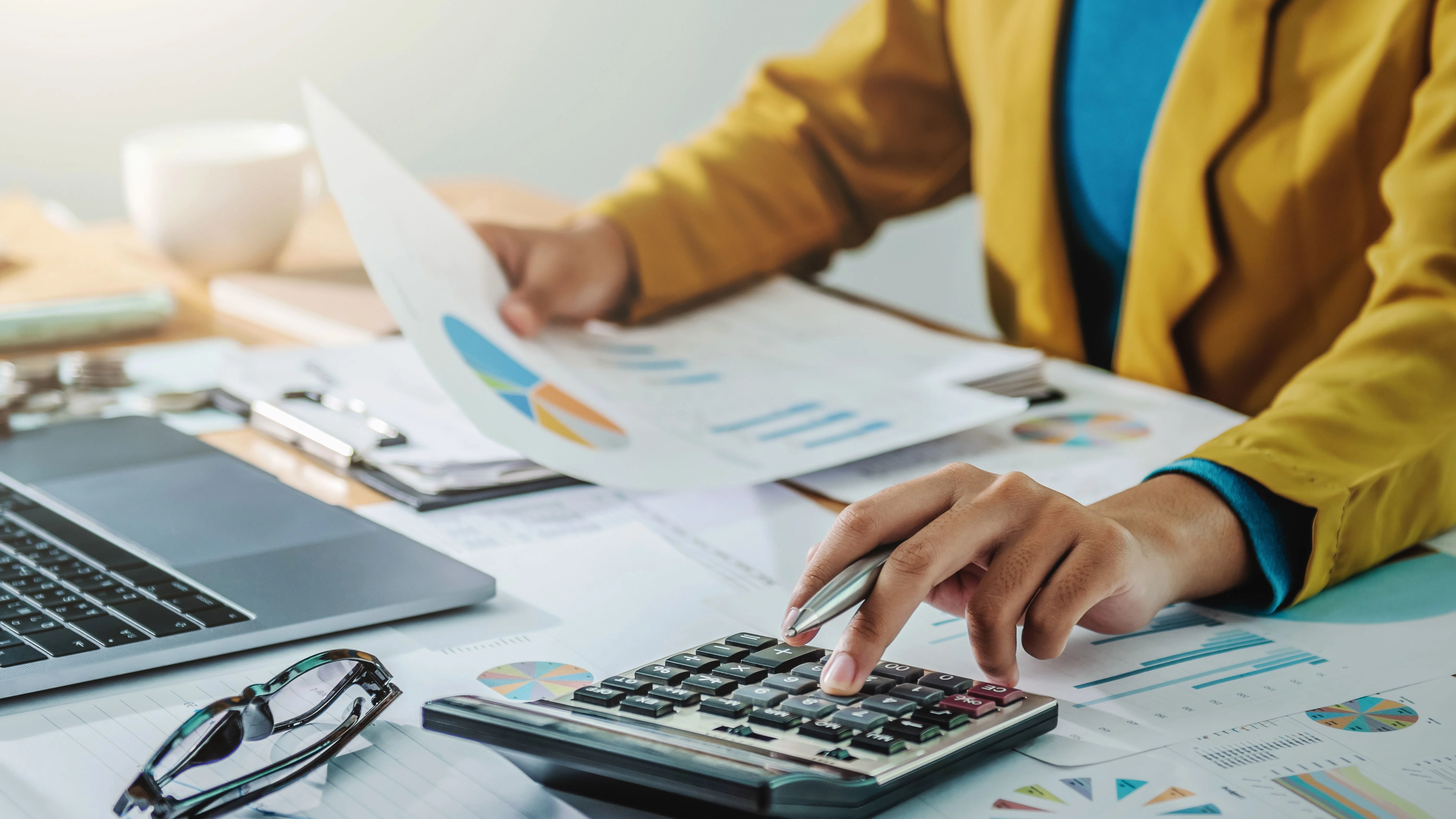 woman looking at 403(b) plan information with a calculator on hand