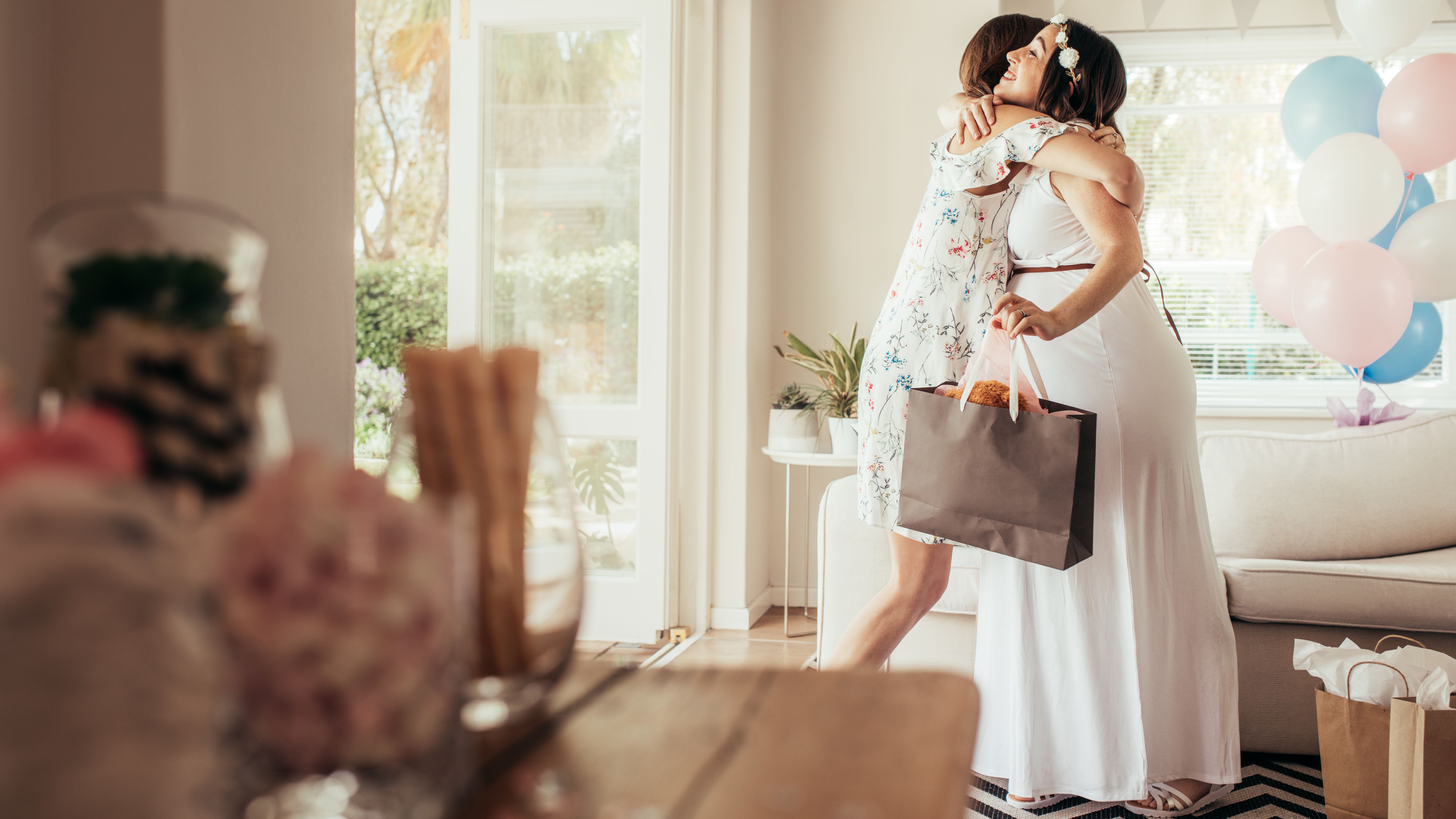 Pregnant woman hugging friend
