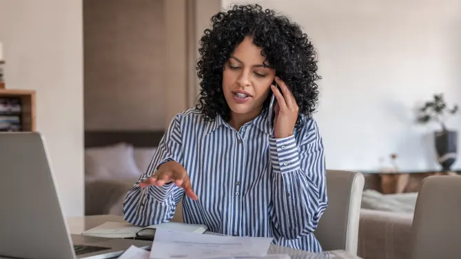 woman talking on her cellphone while working at home