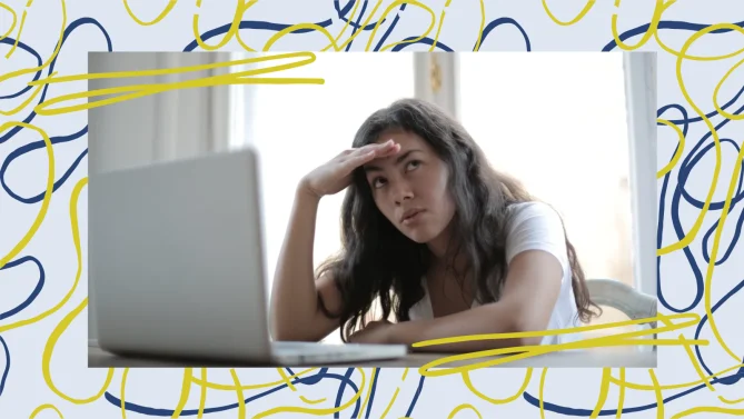 woman with her hand on her hand in front of a laptop looking away