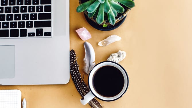 stylish laptop phone and notebook and coffee with feathers crystals