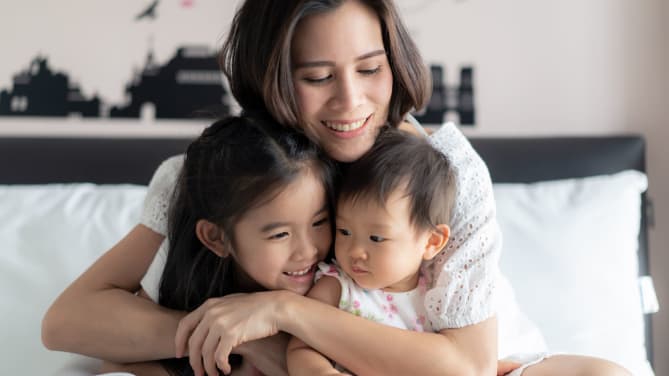 Woman hugging kids.