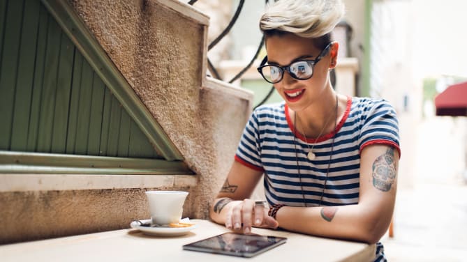 woman typing on tablet outside