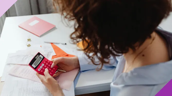 Woman using a calculator, illustrating the challenges of financial stress