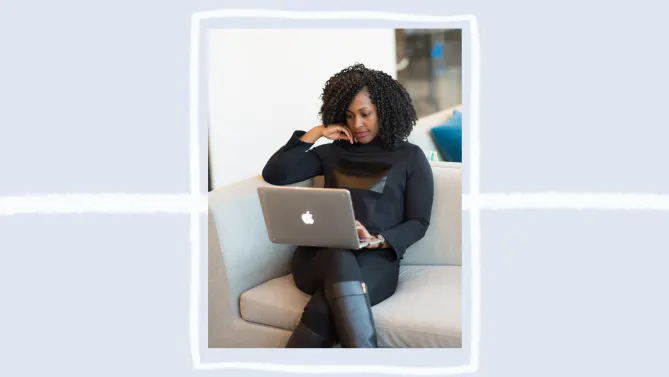 woman sitting on a gray couch with her laptop