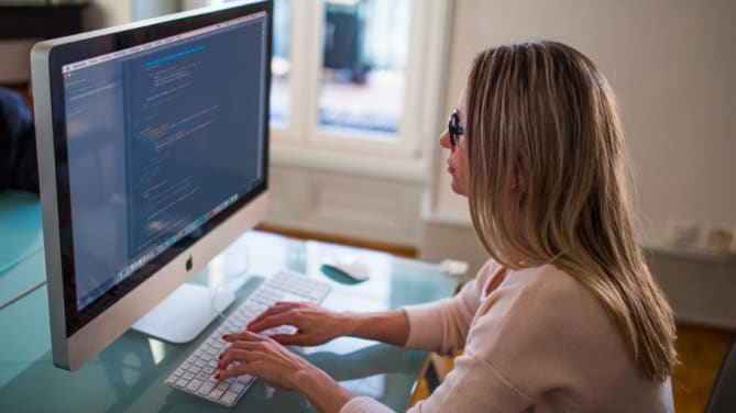 App developer sitting at desk looking at computer