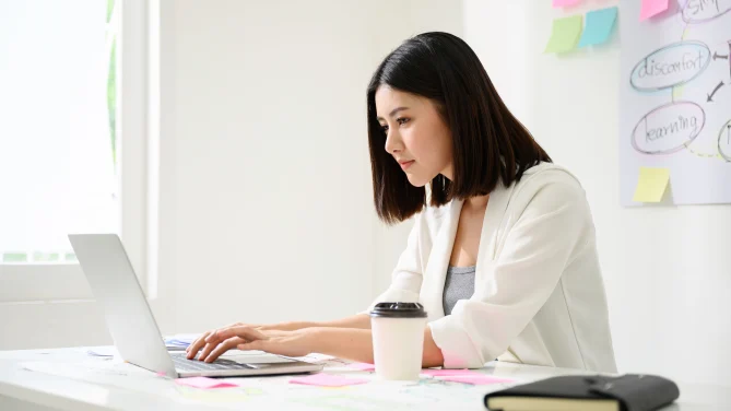 inquisitive looking woman types something on computer