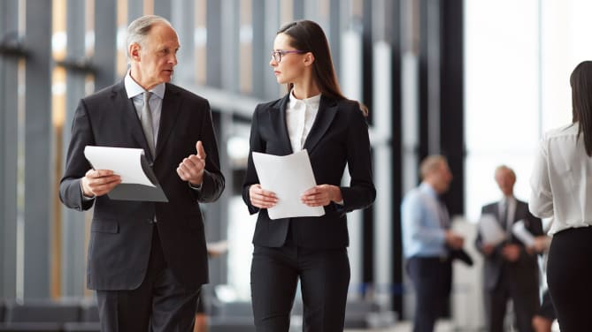 A man and a woman walking in an office
