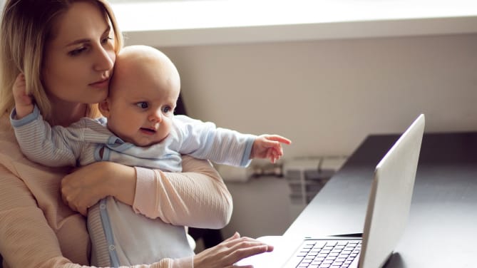Woman on laptop with baby