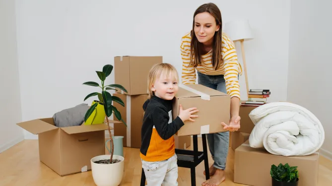 Son helping mother to move boxes, they are vacating old apartment