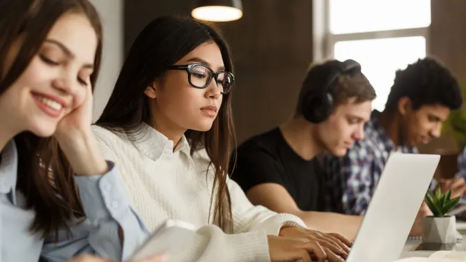 college student writing on a laptop