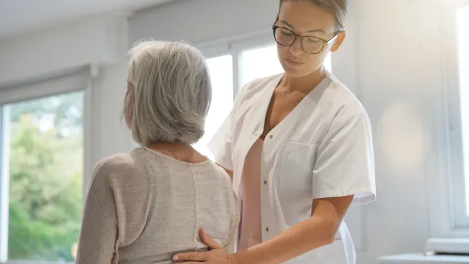chiropractor with hand on patient's back