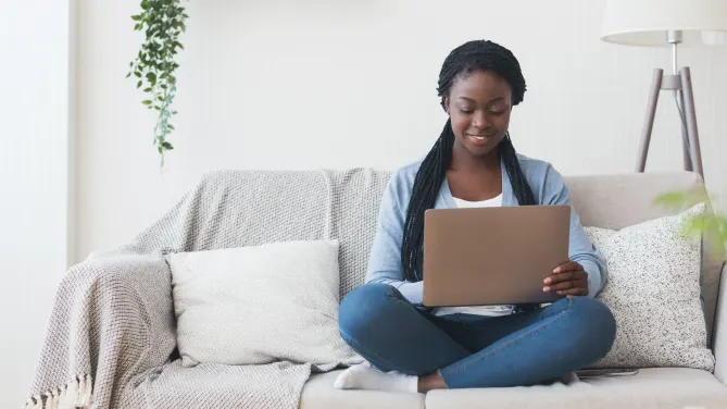 Woman sitting on couch with laptop