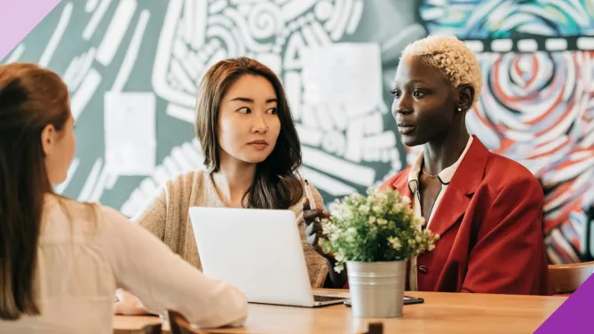 Coworkers in an office setting, illustrating the signs of a jealous coworker