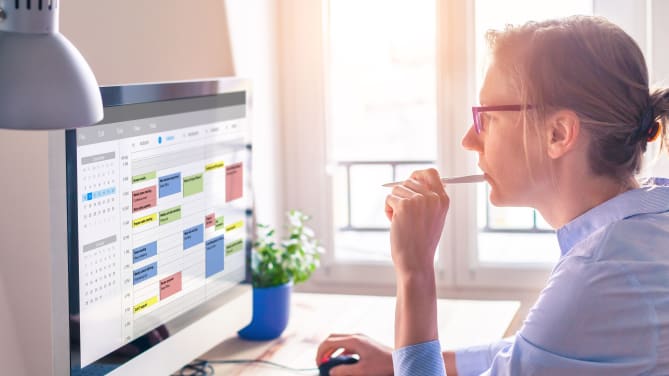 woman looking at calendar on computer