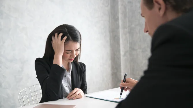 boss criticizing employee, who looks upset