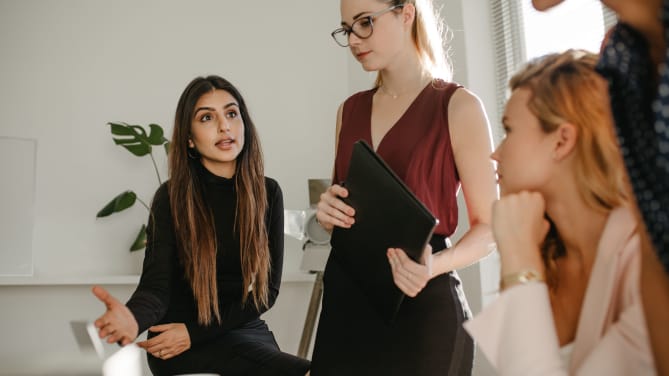 Woman speaking with team members