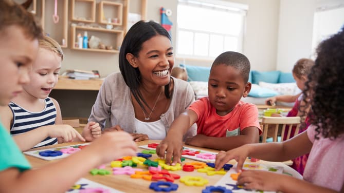 young teacher crouching by group of students