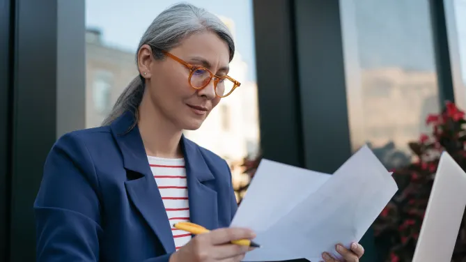 Woman looking at papers thinking